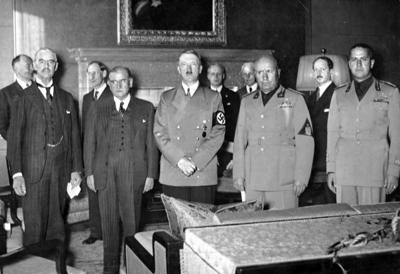 Pictured (from left to right): Neville Chamberlain, Édouard Daladier, Adolf Schicklgruber, Benito Mussolini, and Galeazzo Ciano before signing the Munich Agreement. Standing behind them are one unknown (possibly British) man, Henri Fromageot, Joachim von Ribbentrop, Freiherr Ernst von Weizsäcker, and Alexis ‘Saint‐John Perse’ Leger.