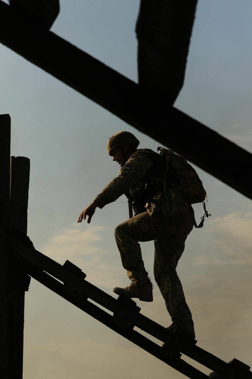 Ukrainian soldier climbing a plank